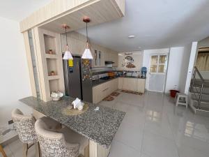 a kitchen with a counter and a black refrigerator at Alojamiento in Ibarra