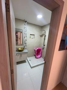 a bathroom with a pink chair in a room at Alojamiento in Ibarra