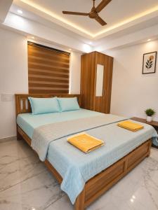 a bedroom with a large bed with two towels on it at Nibras Villas in Varkala