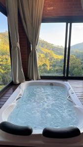 a bath tub sitting in front of a window at Chalé Raízes in Joanópolis