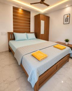 a bedroom with a large bed with two towels on it at Nibras Villas in Varkala