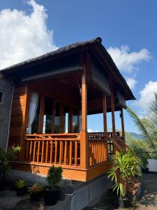 a wooden house with a porch and some plants at Mantra Guesthouse Sidemen in Sidemen