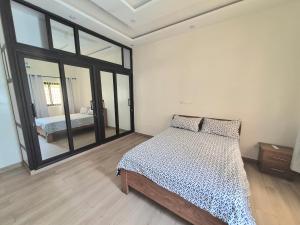 a bedroom with a bed and a large window at EmElla Manor in Komé