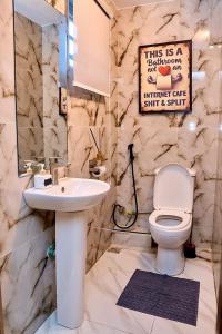 a bathroom with a white toilet and a sink at Luxembourg Apartment in Lagos +14 photos