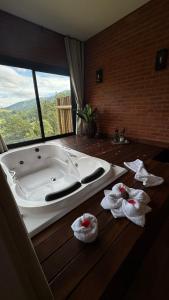 a bath tub in a bathroom with towels on the floor at Chalé Raízes in Joanópolis +35 photos