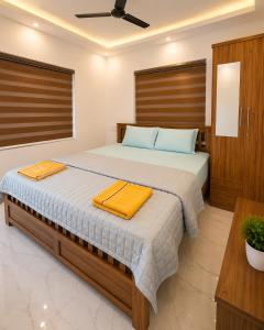 a bedroom with a bed with two towels on it at Nibras Villas in Varkala