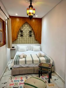 a bedroom with a bed and a chandelier at Riad Maison Eden in Rabat