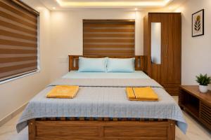 a bedroom with a bed with two towels on it at Nibras Villas in Varkala +112 photos