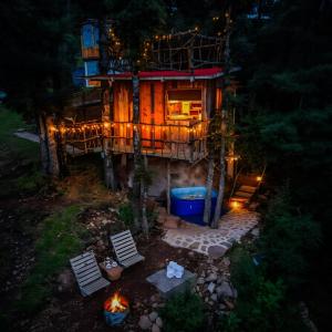 a tree house with a fire in front of it at Biciting Casita en el Árbol con Terraza in Mineral del Chico