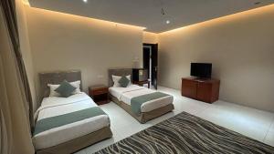 a hotel room with two beds and a flat screen tv at فندق دار العوالي3 in Medina