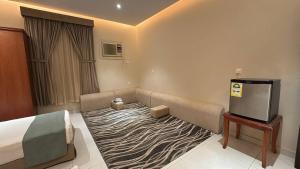 a hotel room with a bed and a flat screen tv at فندق دار العوالي3 in Medina
