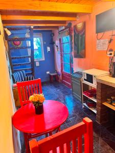 a dining room with a red table and chairs at El Kamaruco Tiny House in El Chalten