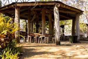 a wooden pavilion with a picnic table in a park at Hidden Valley Cabins & Tours in Coolbie