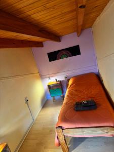a small bed in a room with a rainbow on the wall at El Kamaruco Tiny House in El Chalten