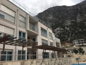 a building with wooden balconies and a mountain in the background at Buena Vista Apartments in Kotor