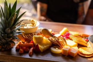 a plate of cheese and crackers and a pineapple at Hidden Valley Cabins & Tours in Coolbie +24 photos