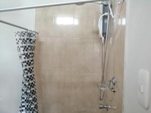 a shower with a black and white shower curtain at Guayobungalows in Máncora +31 photos