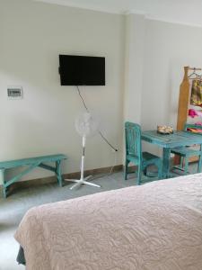 a bedroom with a bed and a table and a tv at Guayobungalows in Máncora