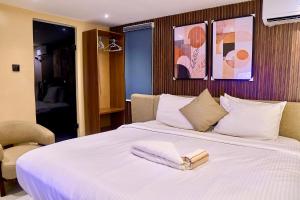 a large white bed with two folded towels on it at Luxembourg Apartment in Lagos