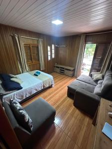 a living room with a bed and a couch at Chalé cipreste 4 Quartos in Gramado +67 photos