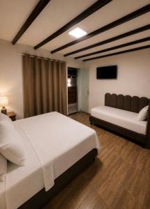a bedroom with two beds and a flat screen tv at Flamingo Beach Pousada in Cabo Frio +54 photos