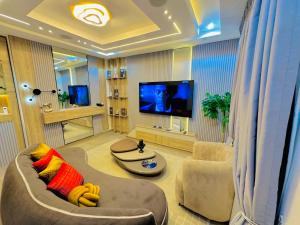 a living room with a couch and a flat screen tv at Armacruz Luxury Hotel And Apartment in Warri Airport