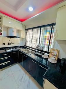 a kitchen with a black and white counter top at Armacruz Luxury Hotel And Apartment in Warri Airport