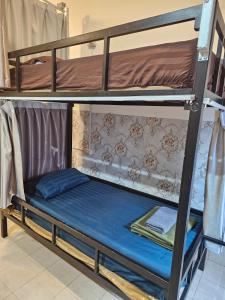 a bunk bed with a blue mattress on top at Pakse Green Adventure Hostel Two in Pakse