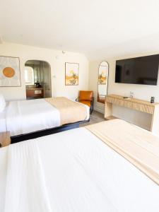 ein Hotelzimmer mit zwei Betten und einem Flachbildfernseher in der Unterkunft The Alcala Hotel Mission Valley Seaworld in San Diego + 51 Fotos