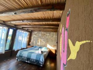 a bedroom with a bed with a painting on the wall at Velas del Lago in Piedras Moradas