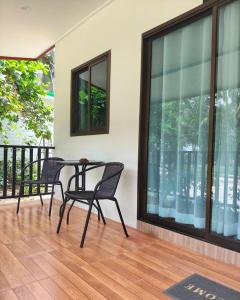 a patio with a table and chairs on a balcony at First light beach bungalow in Ko Phangan