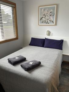 a bedroom with a bed with two towels on it at Tumby Bay Caravan Park in Tumby Bay