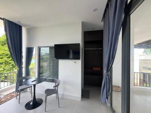 a dining room with a table and a tv at Roooftop villa can ho penhouse Tay ninh in Tây Ninh