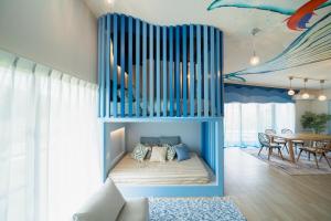 a bedroom with a blue bunk bed with a table at The Mural Art House Bise in Motobu