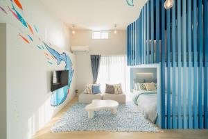 a bedroom with a bed and a table in a room at The Mural Art House Bise in Motobu