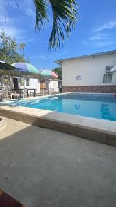 a large swimming pool with tables and umbrellas at Mary Patsy House in Puerto López