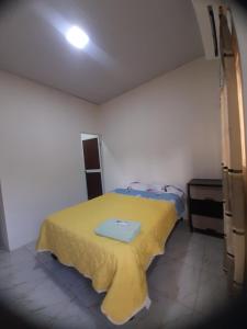 a bedroom with a bed with a yellow blanket on it at Mary Patsy House in Puerto López