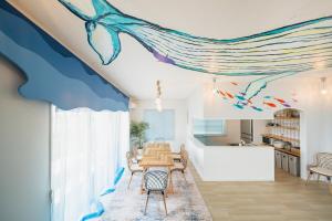a dining room with a dolphin mural on the ceiling at The Mural Art House Bise in Motobu