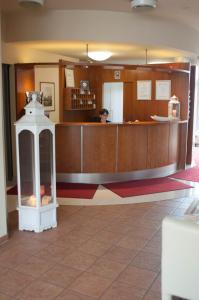 a lobby with a counter with a woman in the background at Hotel Stadt Püttlingen in Püttlingen