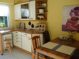 a kitchen with a wooden table and a table and chairs at Trade fair and holiday accommodation in Oberursel