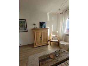 a living room with a cabinet and a chair at Trade fair and holiday accommodation in Oberursel