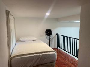 a small bedroom with a bed and a fan at D'Alor Homestay in Pasir Mas