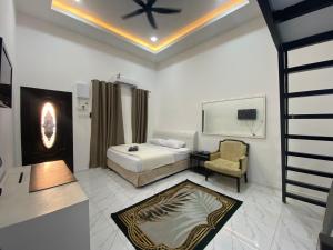 a hotel room with a bed and a chair at D'Alor Homestay in Pasir Mas