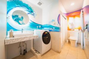 a bathroom with a wave painted on the wall at The Mural Art House Bise in Motobu +84 photos