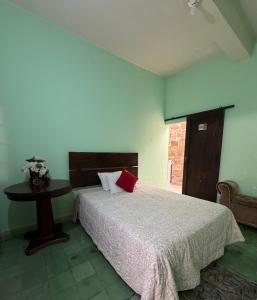 a bedroom with a bed and a table in it at Hotel Puerta de Jade in Ciudad Valles