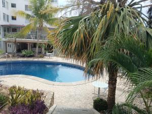 a swimming pool with a palm tree next to a building at Sierra 5 in Acapulco