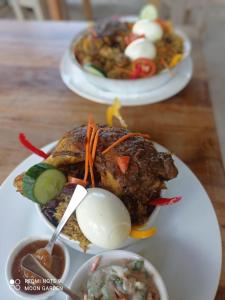 two plates of food on a wooden table at Moon Garden Hotel And Restaurant in Arugam Bay +69 photos