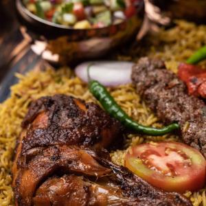 a plate of food with meat and vegetables on rice at Moon Garden Hotel And Restaurant in Arugam Bay