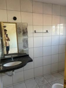 a man taking a picture of a bathroom mirror at Apto a 50m da ExpoCrato in Crato