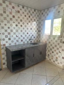 a kitchen with a sink in a room with wallpaper at Apto a 50m da ExpoCrato in Crato
